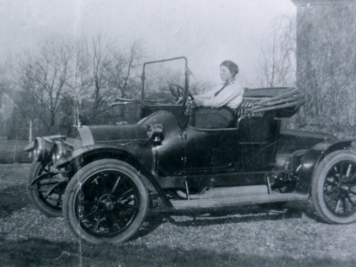 K-1, Spyker van F.D. Kolff v. Oosterwijk uit Kruiningen, aldaar in 1914 met een van zijn dochters achter het stuur. De achterbank is verwijderd en een linnen kap is op de voorbank gemonteerd.<br />Bron: collectie C. Komejan, via Sjaak v. Loo, Kruiningen<br />
